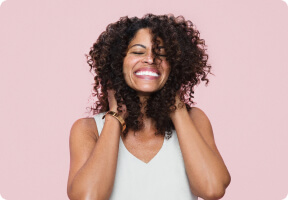Mujer tocándose su intenso cabello rizado castaño