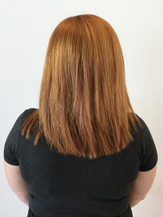 Foto de antes: vista trasera de una mujer con cabello castaño claro desigual de longitud media y raíces crecidas antes de la coloración.