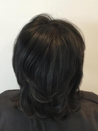 Foto de después: vista trasera de una mujer con cabello corto y negro sin canas después de la coloración.